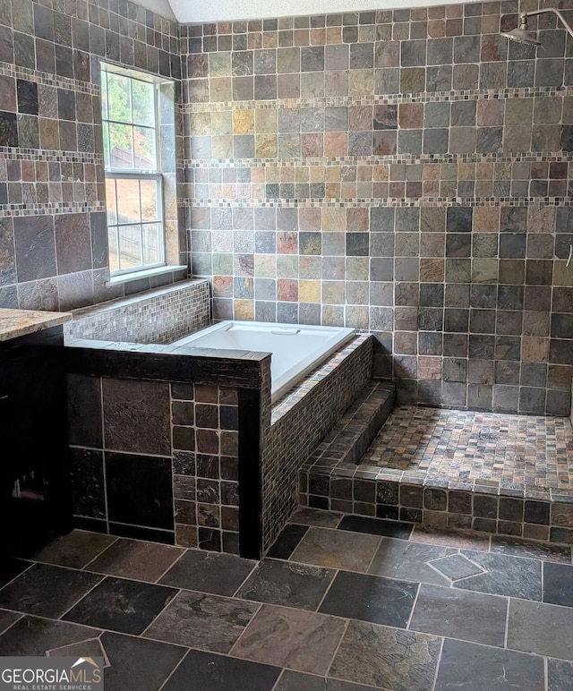 bathroom with tile walls and tiled tub