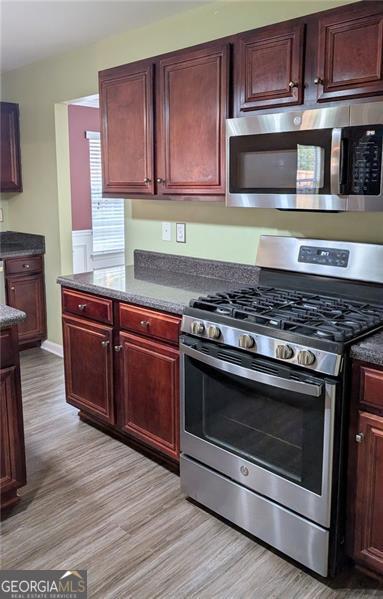 kitchen featuring appliances with stainless steel finishes and light hardwood / wood-style floors