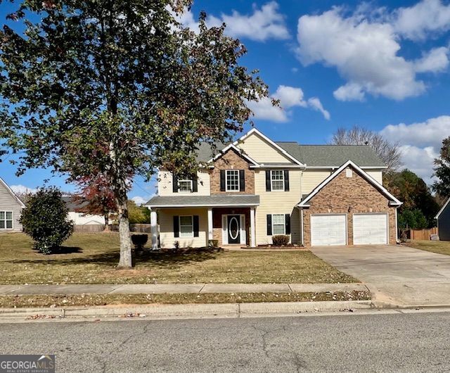 view of front of home with a front yard, a porch, and a garage