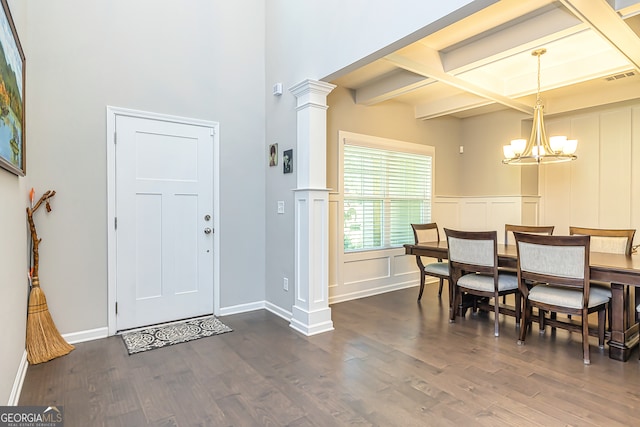 foyer featuring a notable chandelier, dark hardwood / wood-style floors, beamed ceiling, and decorative columns