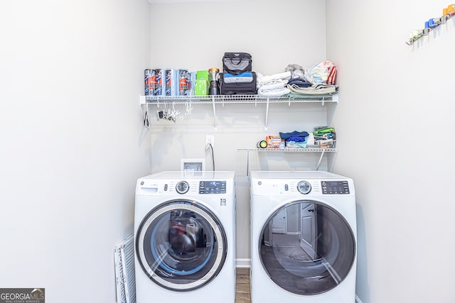 laundry room with hardwood / wood-style flooring and separate washer and dryer