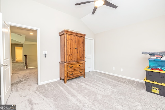 interior space featuring lofted ceiling, light colored carpet, and ceiling fan