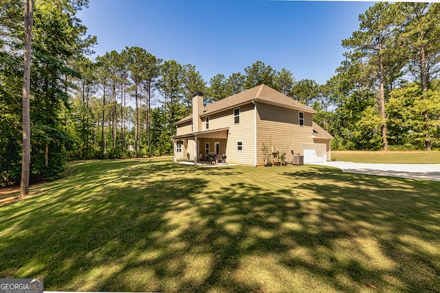 exterior space with central AC, a garage, and a lawn