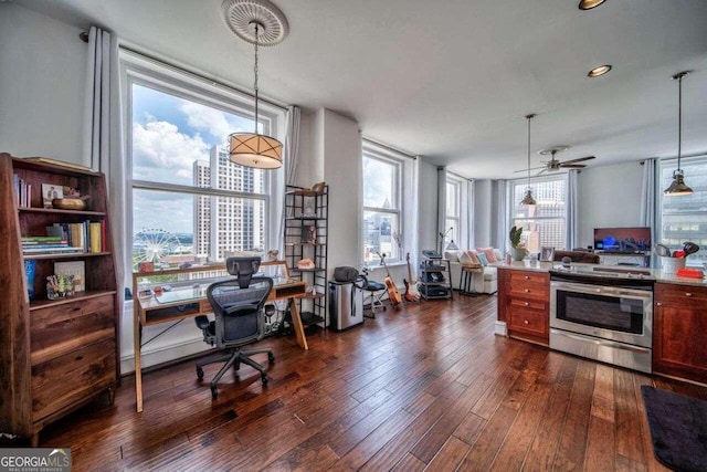 kitchen with stainless steel range with electric stovetop, a healthy amount of sunlight, pendant lighting, and dark hardwood / wood-style flooring