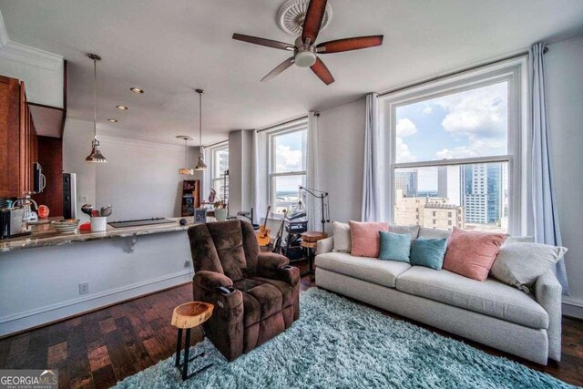 living room with ceiling fan, a healthy amount of sunlight, ornamental molding, and hardwood / wood-style floors