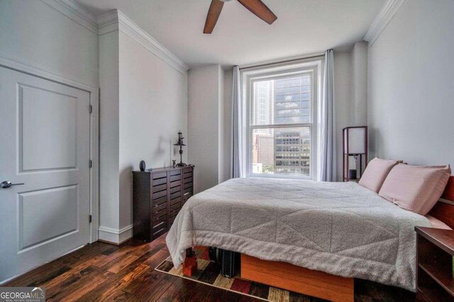 bedroom featuring ornamental molding, dark hardwood / wood-style floors, and ceiling fan