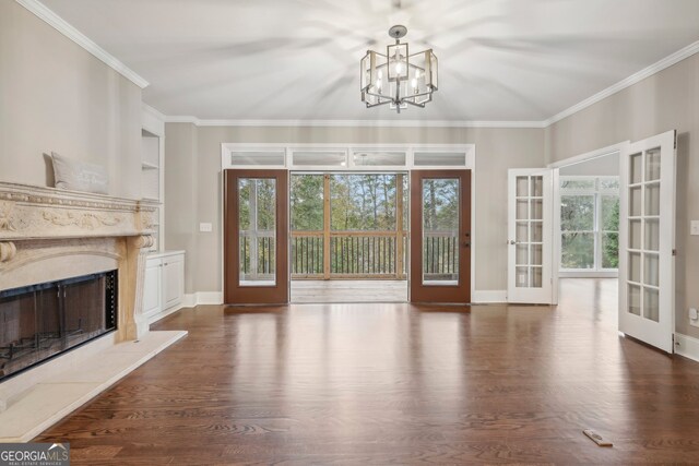 unfurnished living room with a premium fireplace, french doors, ornamental molding, and dark hardwood / wood-style flooring