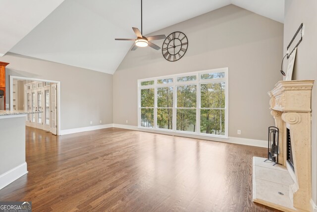 unfurnished living room with ceiling fan, high vaulted ceiling, dark hardwood / wood-style flooring, and a fireplace