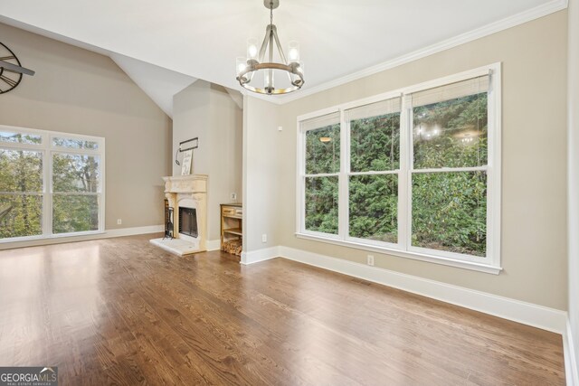 unfurnished living room featuring crown molding, wood-type flooring, and a chandelier