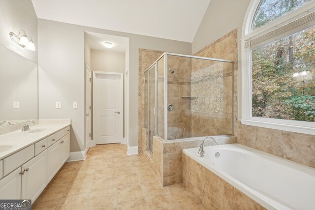 bathroom with vanity, plus walk in shower, tile patterned floors, and vaulted ceiling