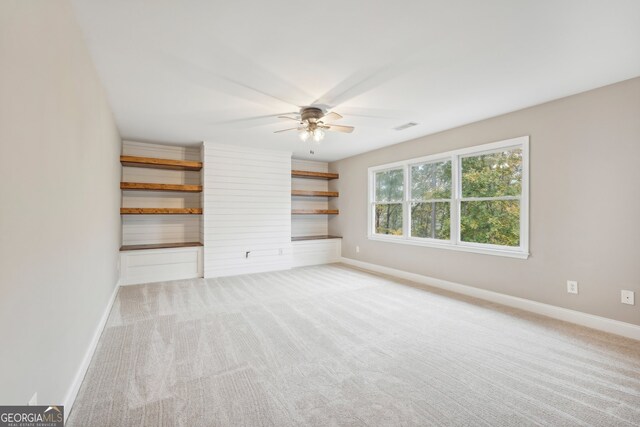 unfurnished living room featuring light colored carpet and ceiling fan