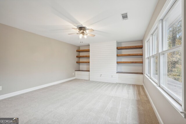 unfurnished room featuring ceiling fan, carpet floors, and plenty of natural light