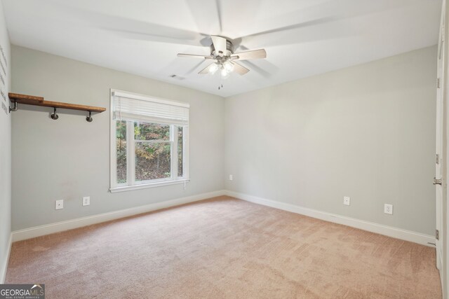 carpeted spare room with ceiling fan