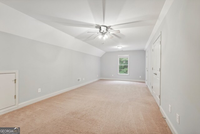 bonus room with light carpet, lofted ceiling, and ceiling fan