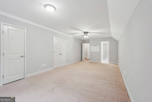 bonus room featuring lofted ceiling, light carpet, and ceiling fan