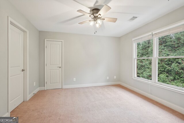 carpeted spare room with ceiling fan