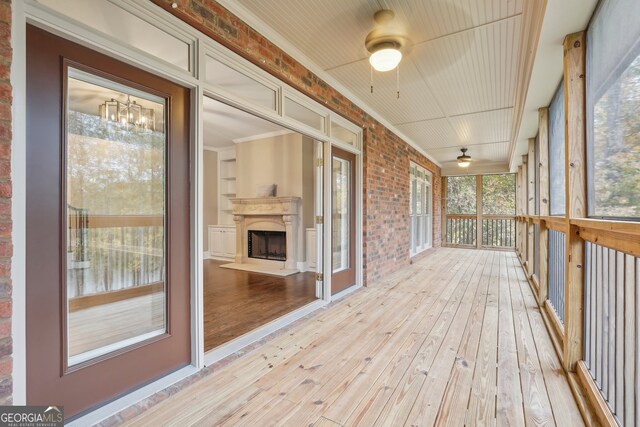 unfurnished sunroom featuring ceiling fan