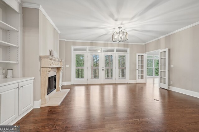 unfurnished living room with french doors, dark hardwood / wood-style floors, plenty of natural light, and a high end fireplace