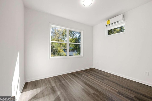 unfurnished room with dark wood-type flooring and an AC wall unit