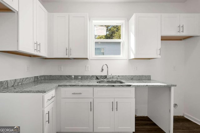 kitchen featuring white cabinets, sink, dark hardwood / wood-style floors, and light stone countertops