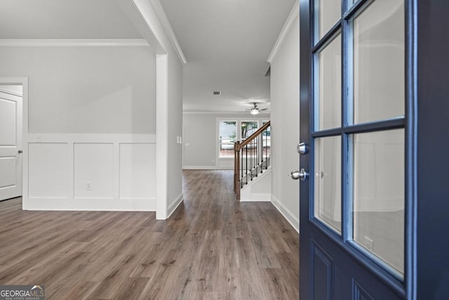 foyer entrance with wood-type flooring and ornamental molding