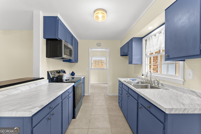 kitchen featuring appliances with stainless steel finishes, light tile patterned flooring, blue cabinetry, and sink