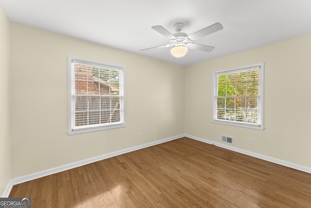 unfurnished room featuring ceiling fan, hardwood / wood-style flooring, and plenty of natural light