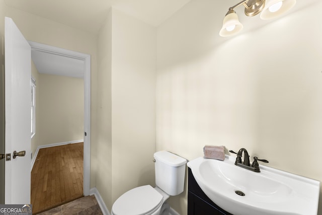 bathroom featuring toilet, vanity, and wood-type flooring