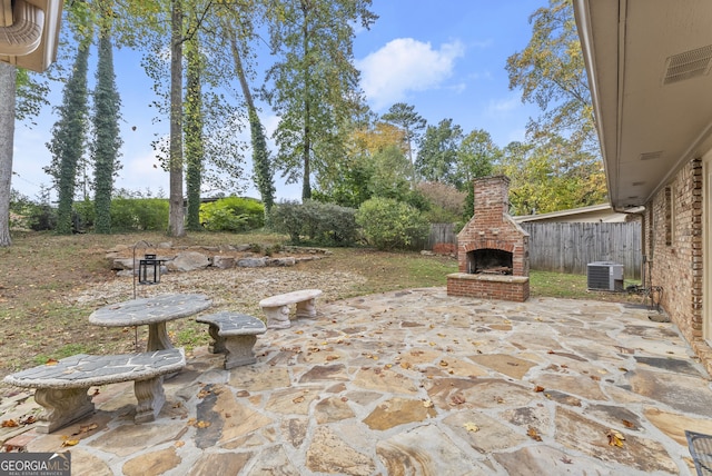 view of patio featuring central air condition unit and an outdoor brick fireplace