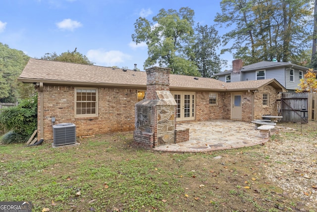 rear view of house with central AC, a patio, and a lawn