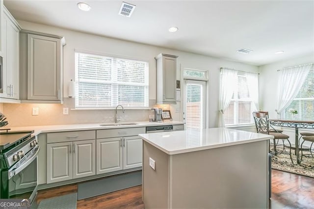 kitchen featuring a healthy amount of sunlight, sink, a kitchen island, and dark hardwood / wood-style flooring