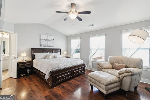 bedroom featuring lofted ceiling, ensuite bath, dark wood-type flooring, and ceiling fan