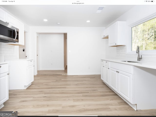 3363 Delmar Ln NW, Atlanta, GA 30331 - kitchen featuring stainless steel microwave, a sink, light countertops, recessed lighting, and backsplash