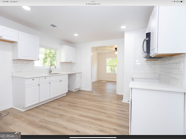 kitchen with sink, white cabinetry, ceiling fan, decorative backsplash, and light hardwood / wood-style flooring