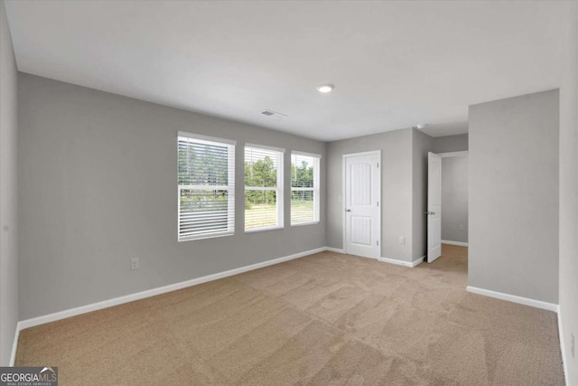 unfurnished room featuring light carpet