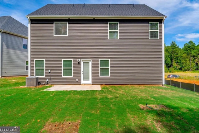 rear view of house featuring a lawn, cooling unit, and a patio