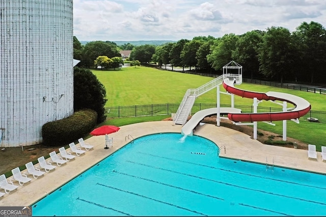 view of pool featuring a lawn and a water slide