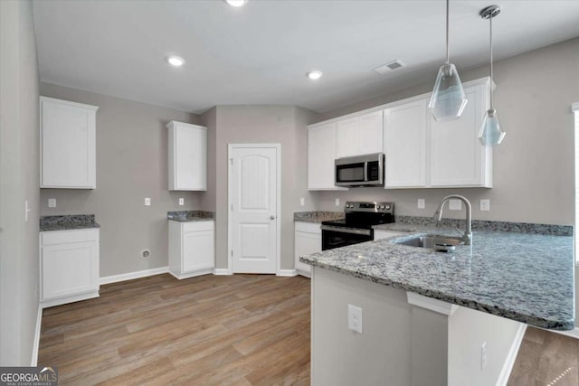 kitchen with light stone countertops, appliances with stainless steel finishes, light wood-type flooring, sink, and white cabinetry