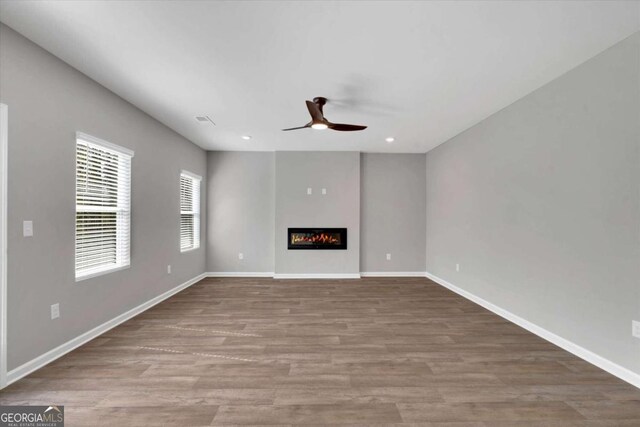 unfurnished living room featuring ceiling fan and hardwood / wood-style floors