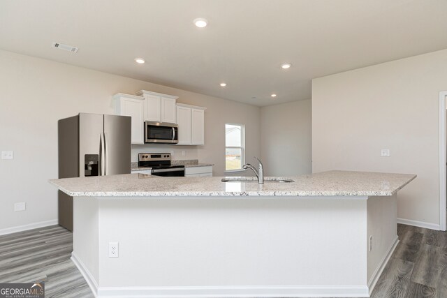 kitchen featuring sink, hardwood / wood-style floors, a large island, white cabinetry, and stainless steel appliances