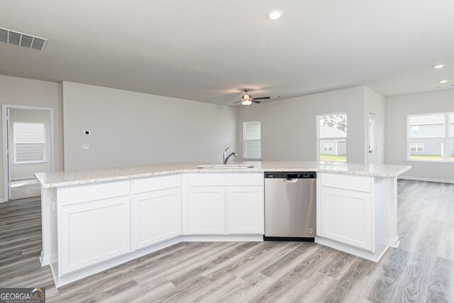 kitchen featuring dishwasher, an island with sink, sink, white cabinetry, and light hardwood / wood-style flooring