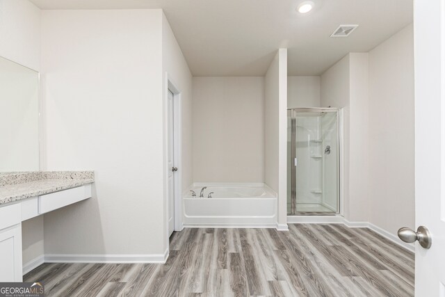 bathroom featuring vanity, independent shower and bath, and hardwood / wood-style flooring