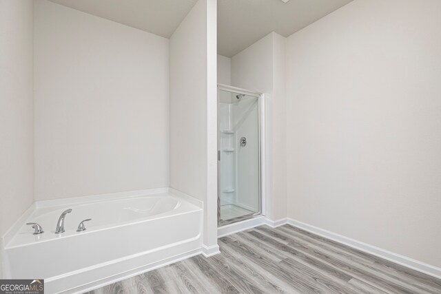 bathroom featuring hardwood / wood-style floors and plus walk in shower