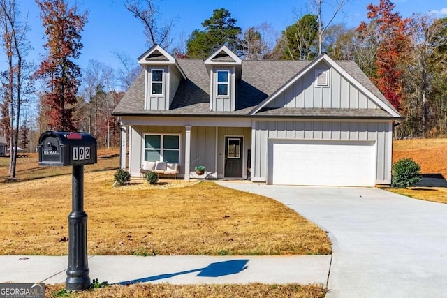 view of front of house featuring a porch, a front yard, and a garage