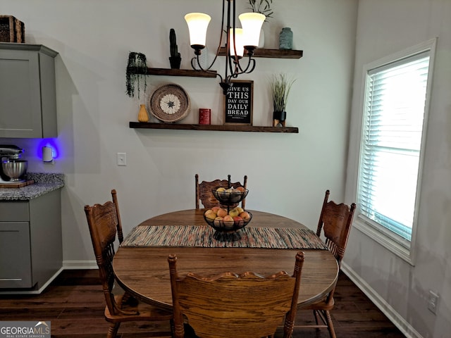 dining room with dark wood-type flooring and a chandelier