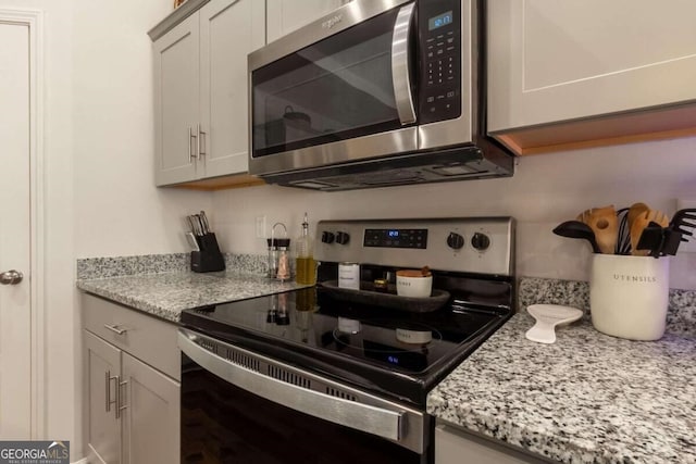 kitchen featuring light stone countertops and appliances with stainless steel finishes