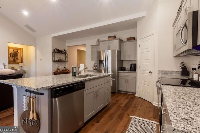 kitchen with gray cabinetry, sink, dark hardwood / wood-style flooring, a kitchen island with sink, and appliances with stainless steel finishes