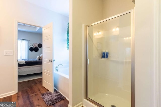 bathroom with hardwood / wood-style floors and independent shower and bath