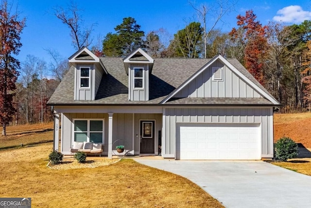 view of front facade with a garage, covered porch, and a front lawn