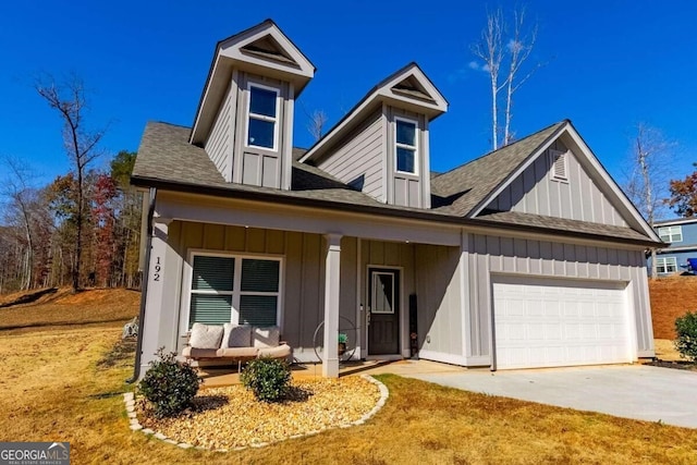 view of front facade with a porch, a garage, and a front lawn